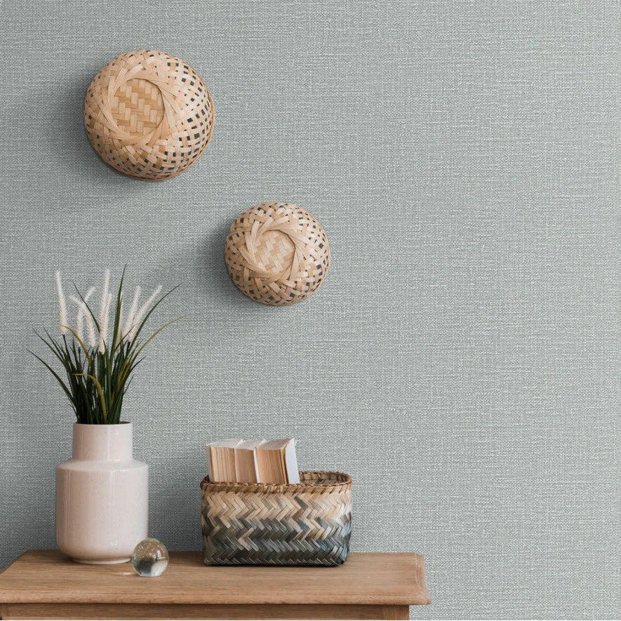 Woven baskets on a textured gray Erismann wallpaper with a wooden shelf and decorative items.