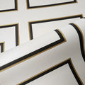 Close-up of gold and black wallpaper roll on a white background