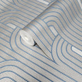 Roll of wallpaper with wavy blue lines on a gray background
