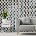 Living room with a geometric patterned wall, gray sofa, and side table.