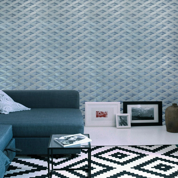 Living room with blue geometric wallpaper, gray sofa, and decorative items on a white wall.