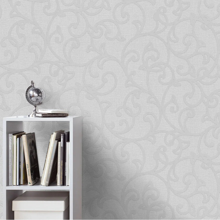 White bookshelf with books against a traditional Erismann wallpaper.