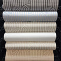 Stack of wallpaper rolls with different patterns and colors