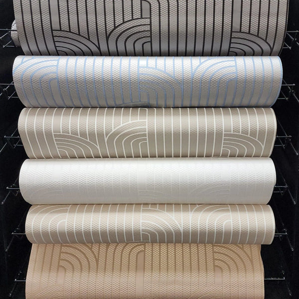Stack of wallpaper rolls with different patterns and colors