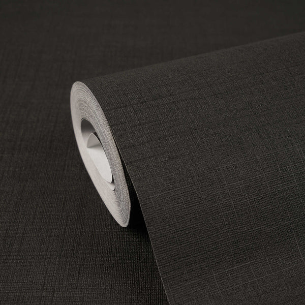 AS Creation Cosiness 792432 black wallpaper roll with a fine crosshatch texture, partially unrolled on a matching surface.