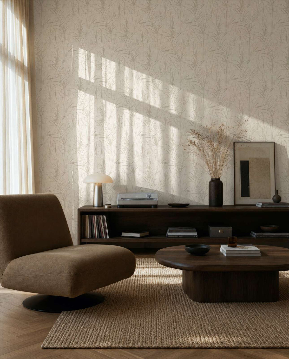 AS Creation Cosiness 792821 living room with cream and white botanical wallpaper, shown behind a low lounge chair and a wooden coffee table.