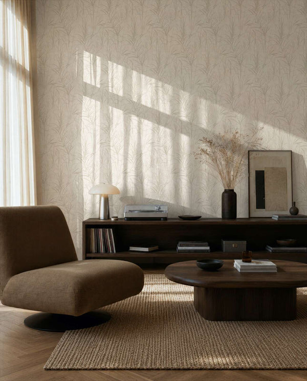 AS Creation Cosiness 792821 living room with cream and white botanical wallpaper, shown behind a low lounge chair and a wooden coffee table.