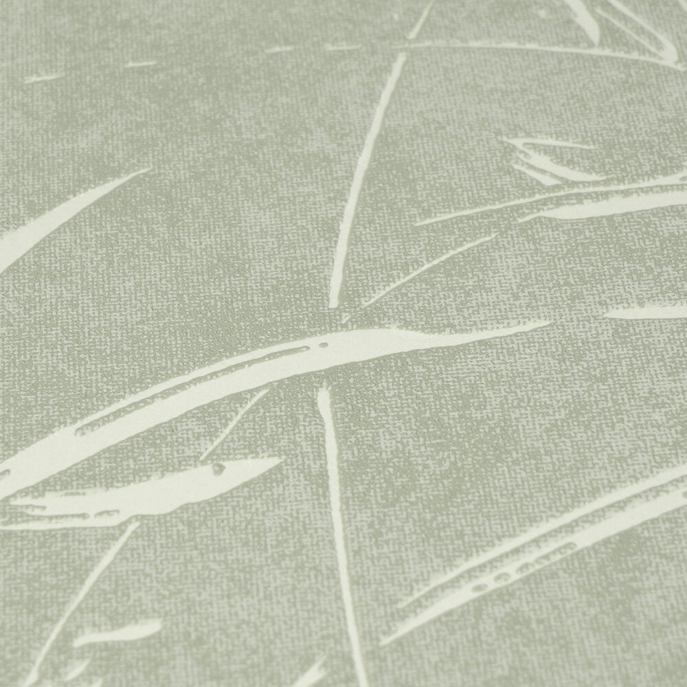 AS Creation Cosiness 792822 close up of green wallpaper with metallic accents, showing abstract sweeping leaf like lines over a speckled ground.