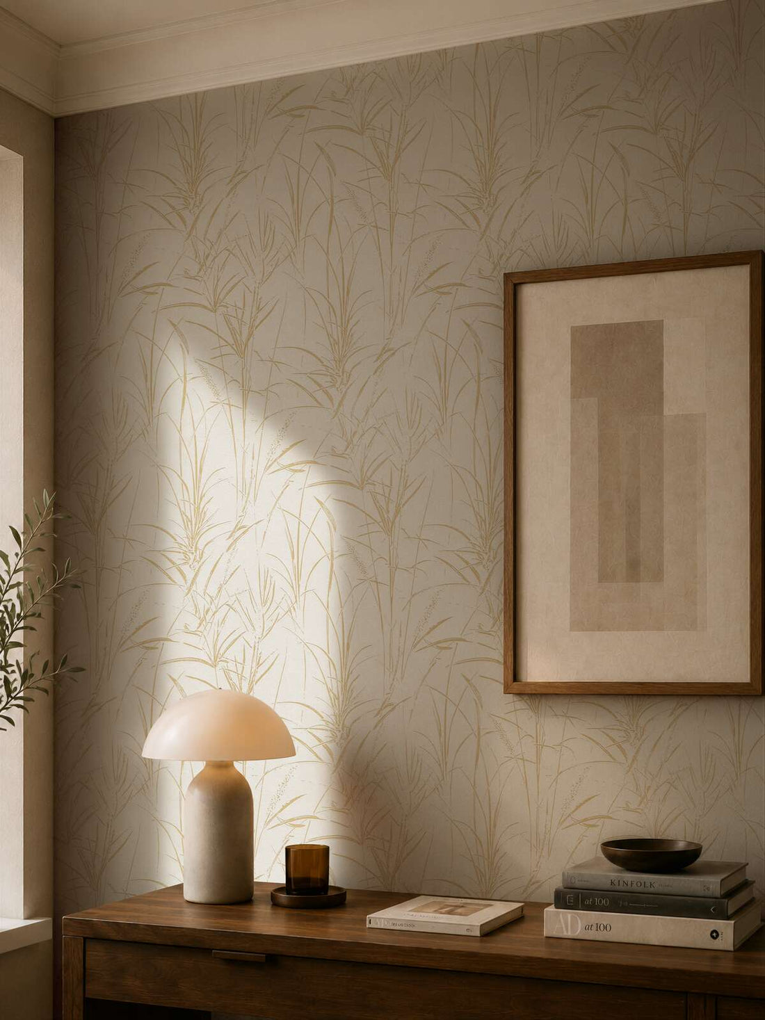 AS Creation Cosiness 792823 botanical reed pattern wallpaper in Brown, Cream, and Metallic shown behind a wood console with a dome table lamp and framed artwork.