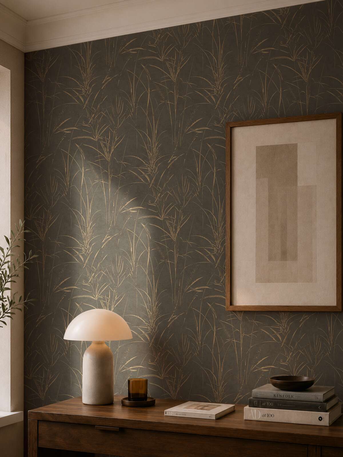 AS Creation Cosiness 792825 living room with Brown, Grey, Metallic botanical design wallpaper behind a framed artwork and a table lamp on a wooden console.
