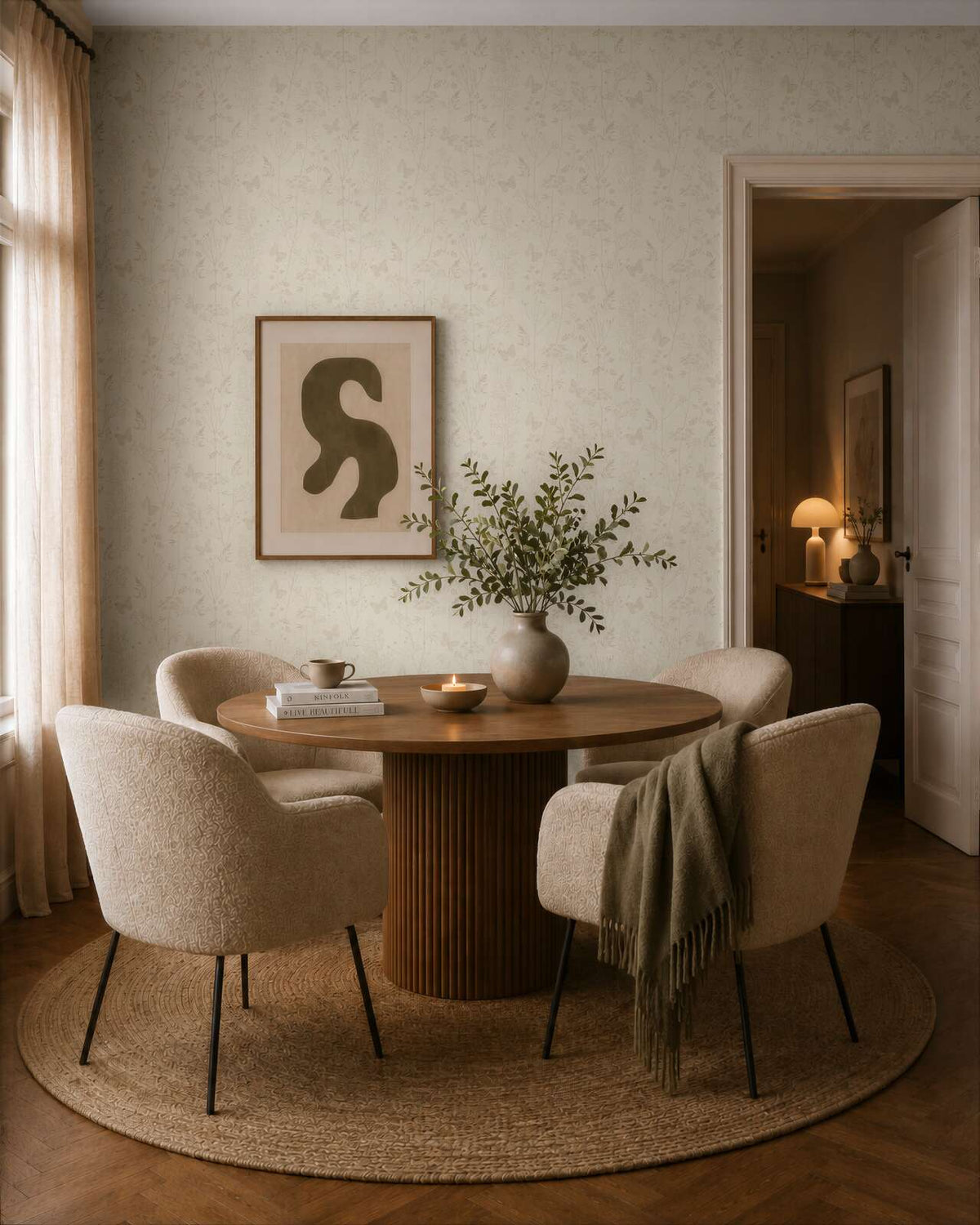 AS Creation Cosiness 792831 dining room with Beige and Brown wallpaper featuring a subtle leaf motif, shown with a round table and upholstered chairs.