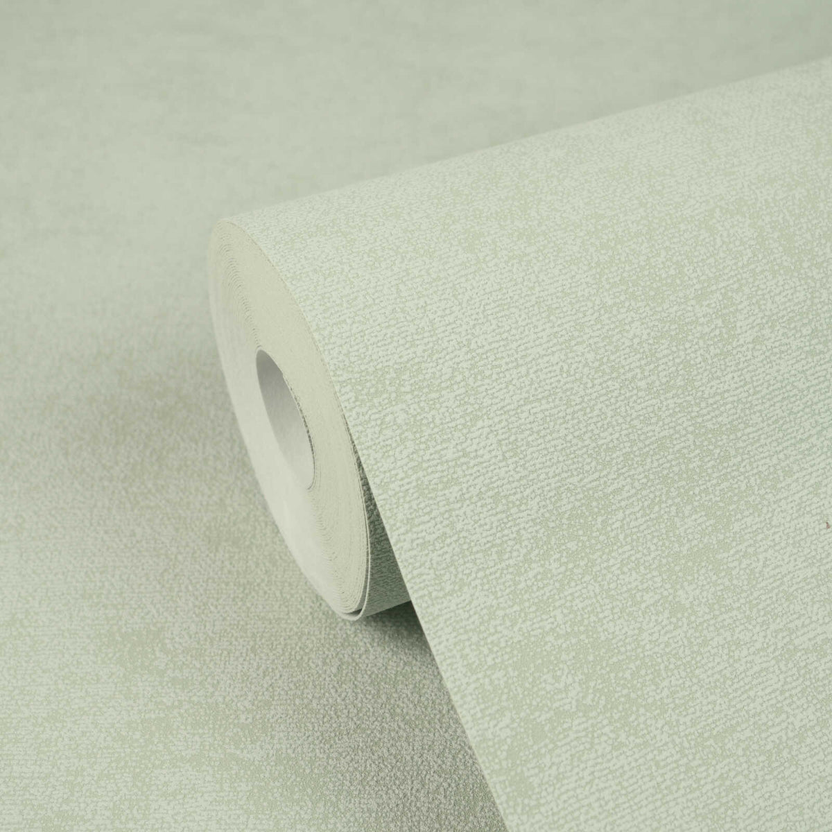 AS Creation Cosiness 792842 green speckled wallpaper roll resting on a matching unrolled sheet.
