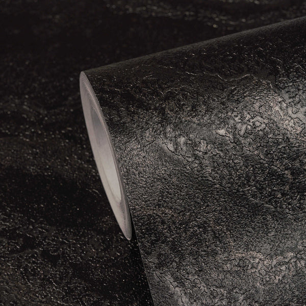 AS Creation Cosiness 793163 black, Metallic wallpaper roll with an irregular organic pattern, shown on a matching surface.
