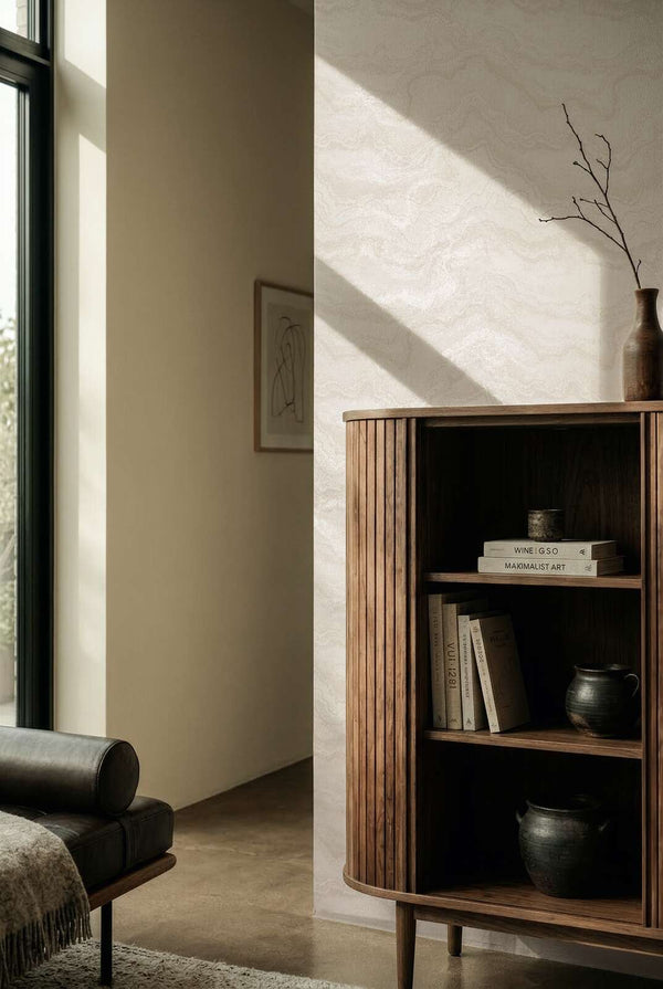 AS Creation Cosiness 793164 a living room with Metallic, White wallpaper featuring an organic wavy pattern; a wooden cabinet and a sofa are visible.