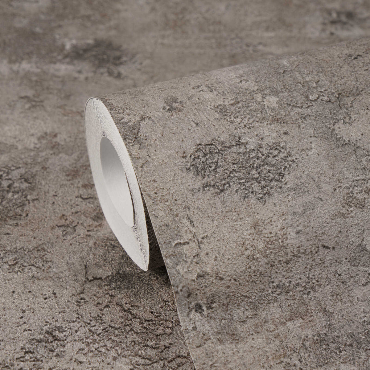 AS Creation Cosiness 793181 wallpaper roll showing a stone effect pattern in Brown, Grey, Metallic on a matching unrolled surface.