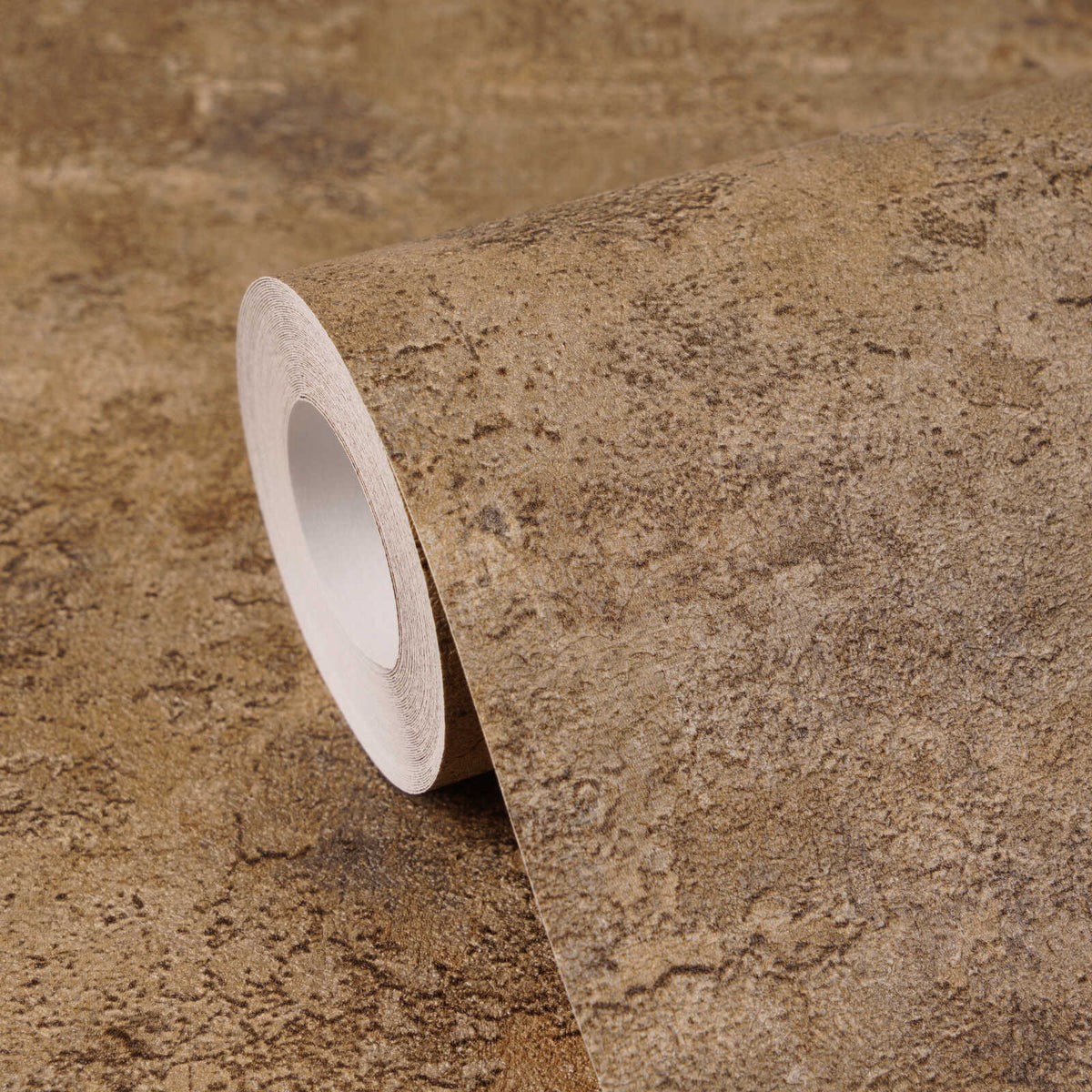 AS Creation Cosiness 793182 wallpaper roll with a mottled, stone like pattern in Brown, Metallic, Orange, shown at an angle on a matching sheet.