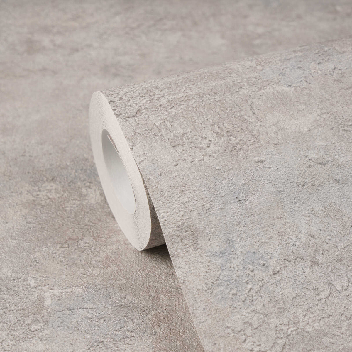 AS Creation Cosiness 793185 close up of a wallpaper roll with a grey, metallic stone look design on a matching surface.