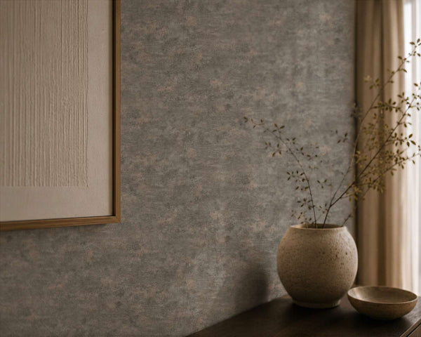 AS Creation Cosiness 793186 mottled wallpaper in Black, Grey, Metallic behind a framed artwork, a round vase with branches, and a small bowl on a table.