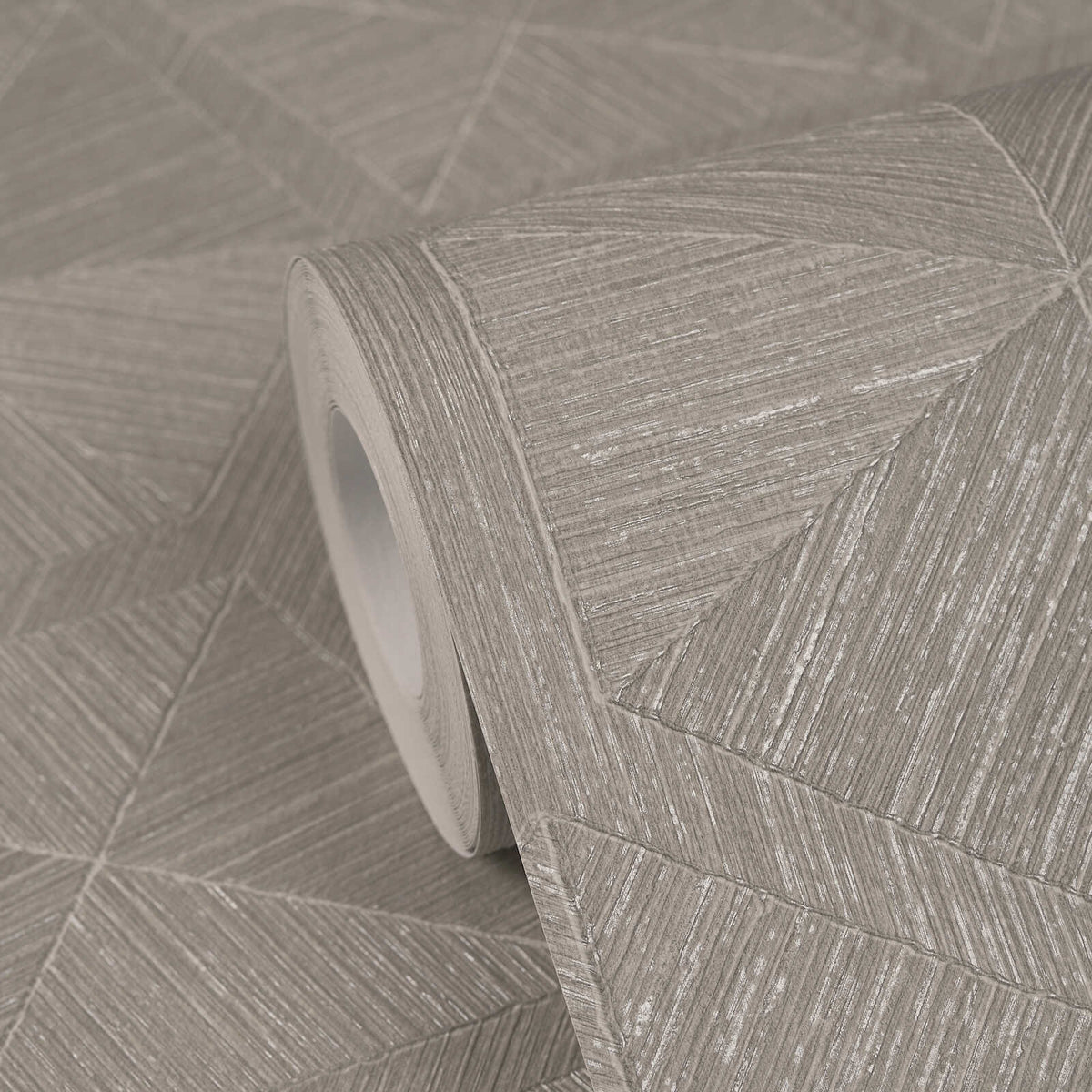 AS Creation Cosiness 793194 close up of a Grey, Metallic geometric wallpaper with diagonal linework forming triangular panels, shown as a partially unrolled roll.