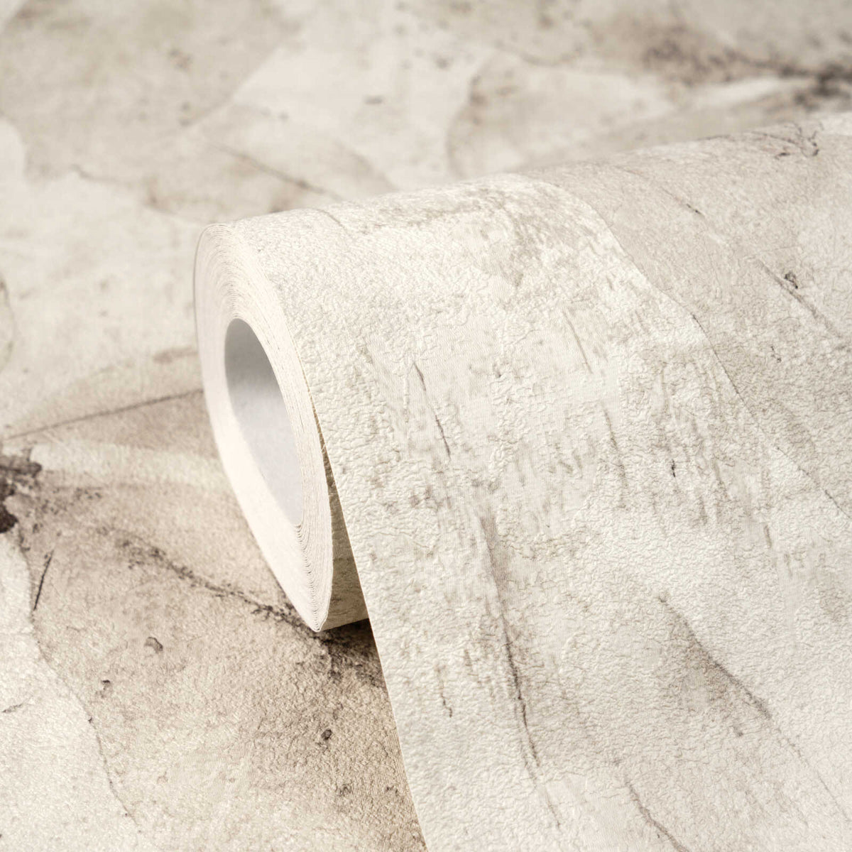 AS Creation Cosiness 793204 close up of a wallpaper roll resting on the matching surface, showing a Beige and Cream abstract mottled design.
