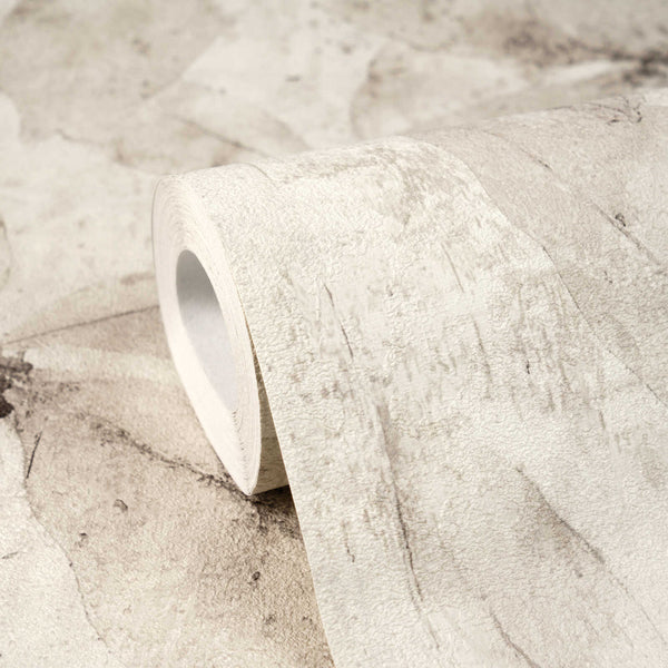 AS Creation Cosiness 793204 close up of a wallpaper roll resting on the matching surface, showing a Beige and Cream abstract mottled design.