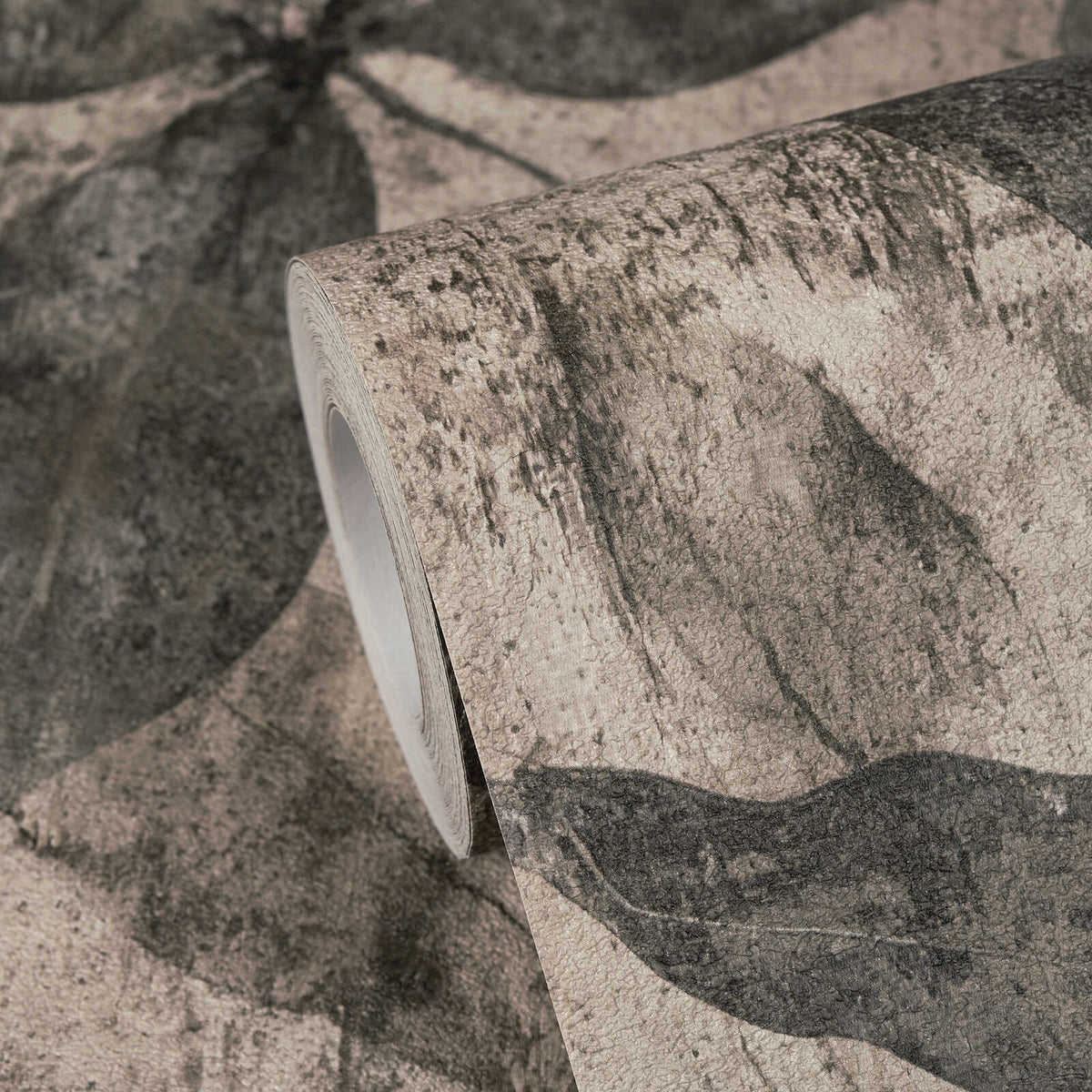 AS Creation Cosiness 793205 close up of a wallpaper roll displaying a beige and brown abstract leaf pattern on the matching surface.