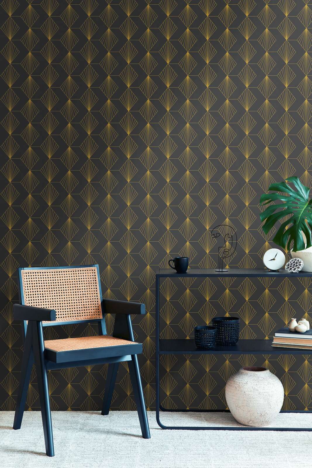 AS Creation French Affair 361562 living room with Black, Metallic wallpaper featuring a geometric fan pattern, shown with a chair and a console table.