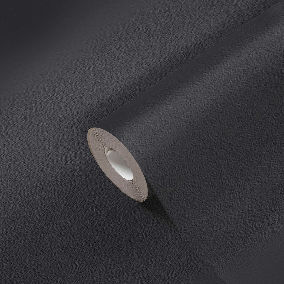 AS Creation French Affair 395726 black textured wallpaper roll on an unrolled sheet, shown in close up to reveal the fine surface grain.