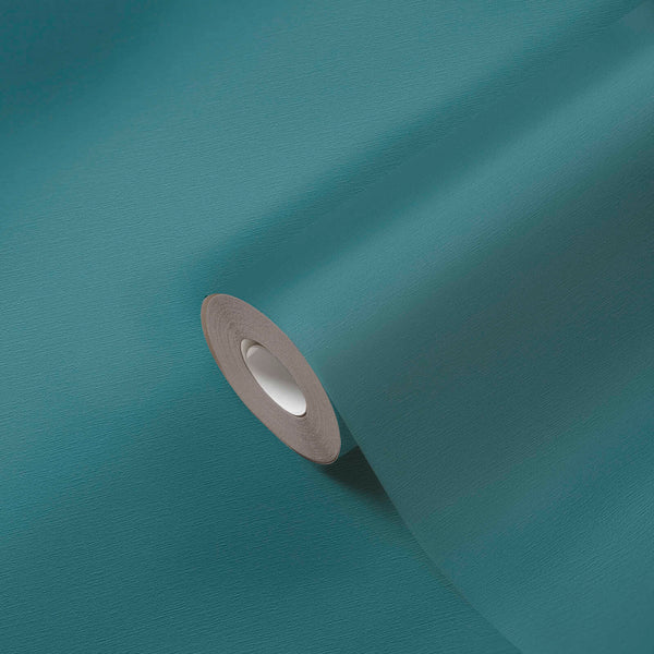 AS Creation French Affair 395764 blue, Green solid color wallpaper roll partially unrolled on a matching surface.