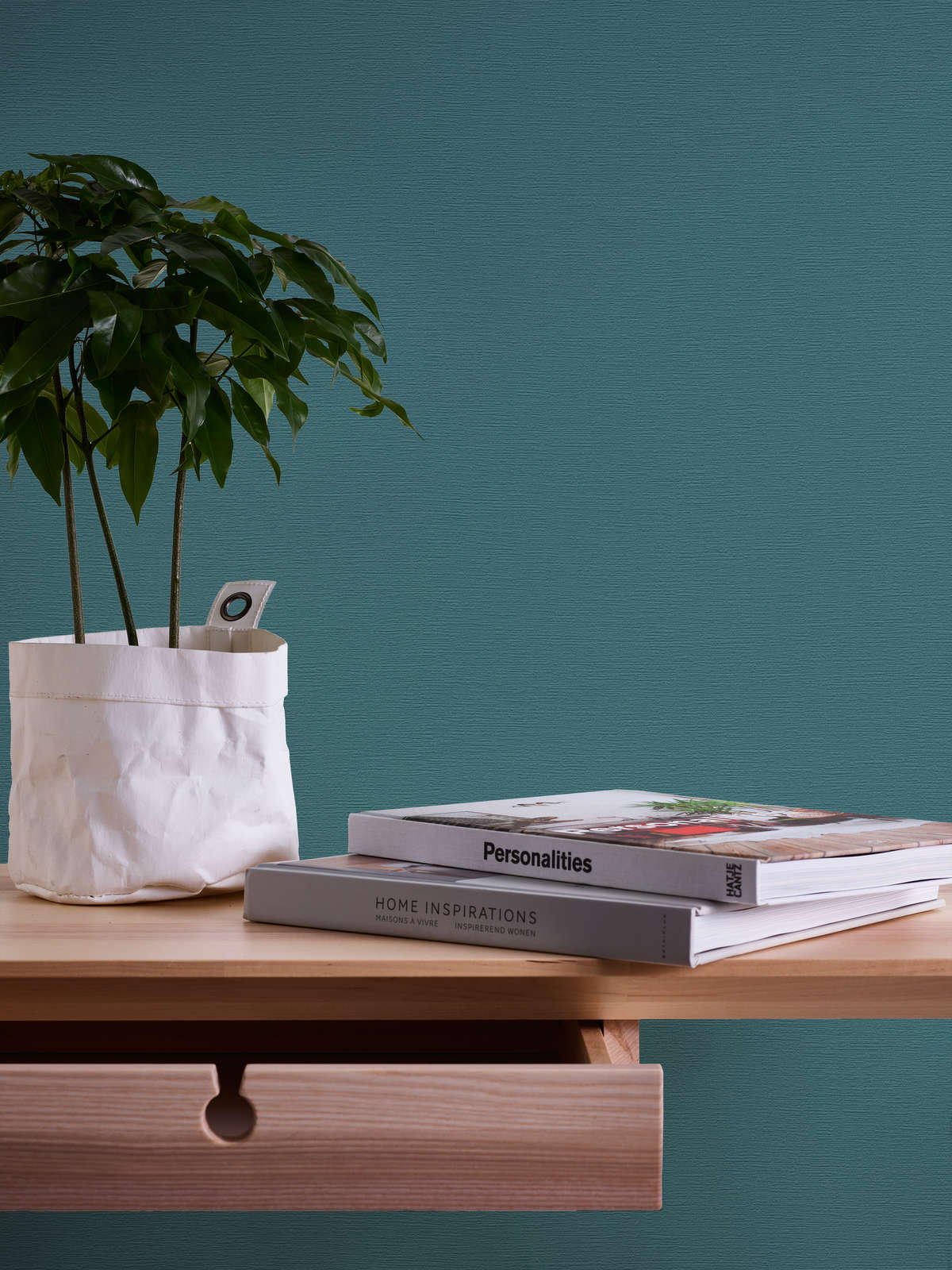 AS Creation French Affair 395764 blue, Green wallpaper with a subtle textured finish behind a wooden shelf with a potted plant and two books.