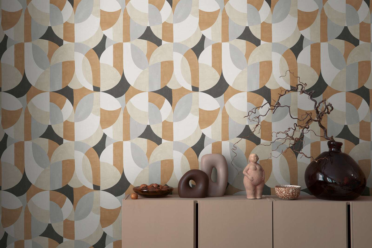 AS Creation French Affair 399321 geometric wallpaper of overlapping circles and arcs in Beige, Black, Brown, Cream, and Grey behind a cabinet topped with sculptural objects and a dark glass vase with a branch.