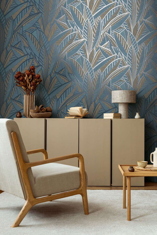 AS Creation French Affair 399335 living room with Blue, Green, Turquoise, Yellow leaf pattern wallpaper behind an armchair and a sideboard.