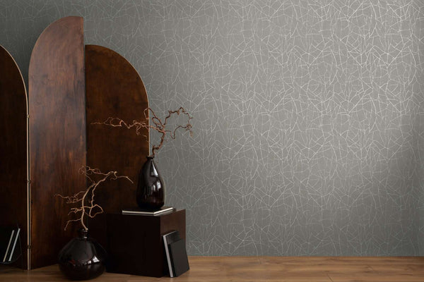 AS Creation French Affair 399343 grey and White abstract line wallpaper with a wood room divider, a cube pedestal, and two dark vases with dried branches on a wood floor.