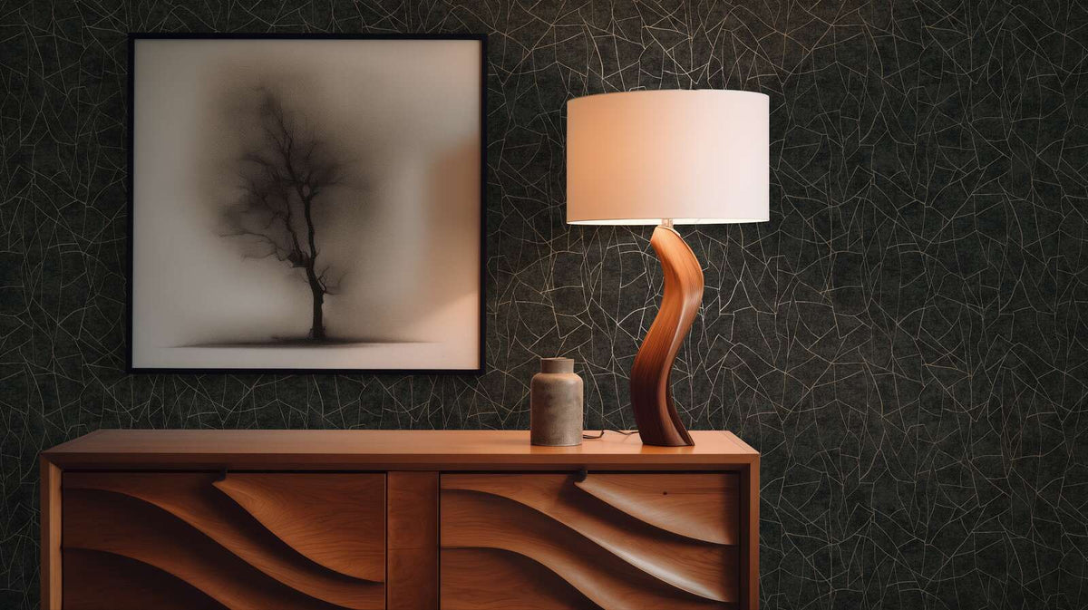 AS Creation French Affair 399344 black, Gold, Metallic abstract line pattern wallpaper with a framed artwork and a sculptural table lamp on a wooden sideboard.