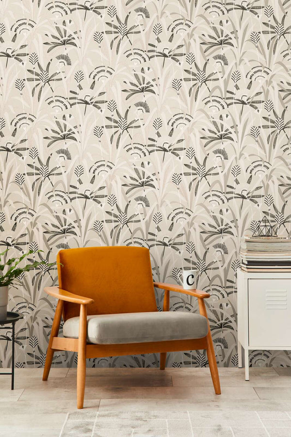 AS Creation French Affair 399361 living room with botanical Beige, Black, Grey, Taupe, and White wallpaper behind an armchair and a small cabinet.
