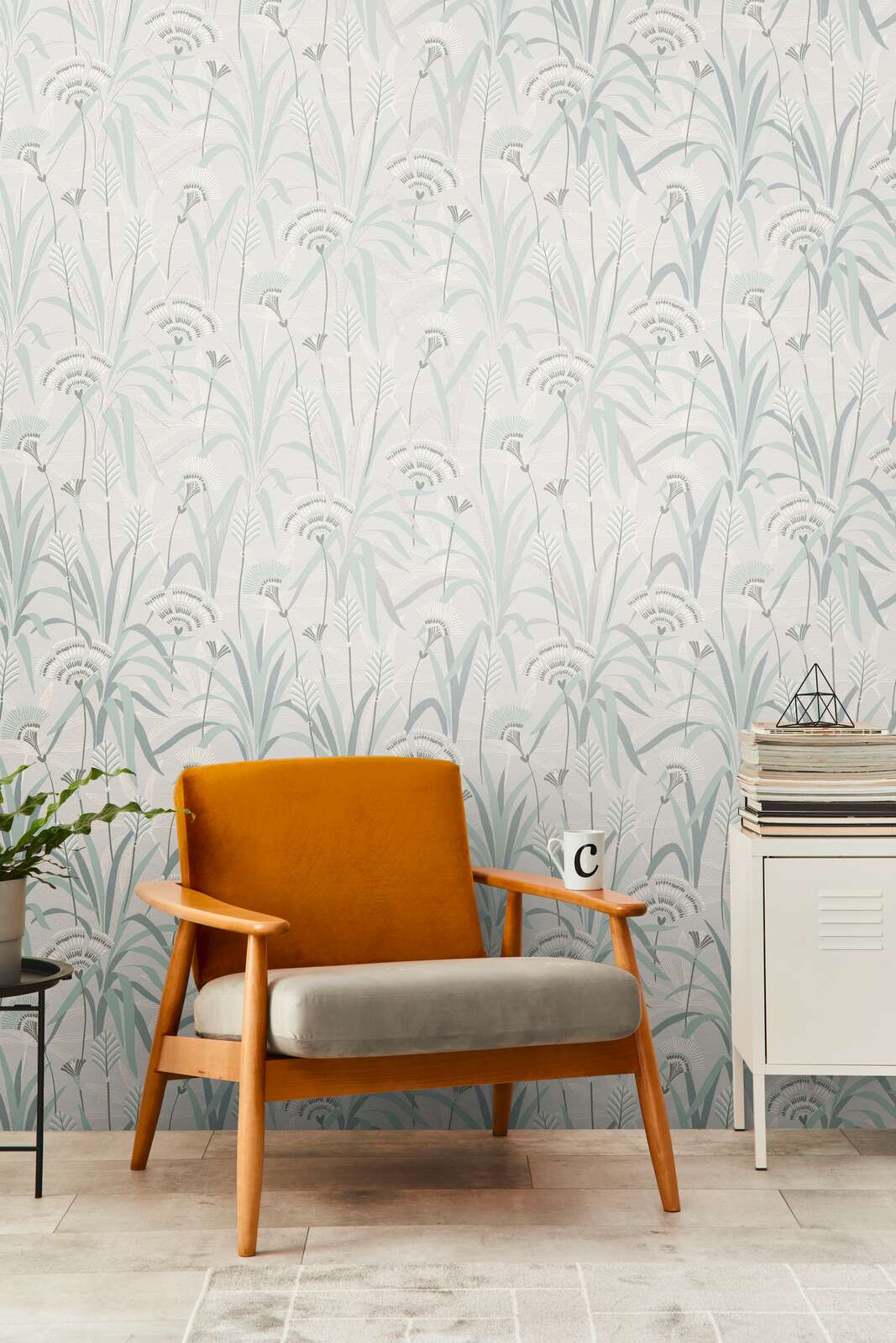 AS Creation French Affair 399363 living room with botanical grass motif wallpaper behind a wood framed armchair and a white cabinet.