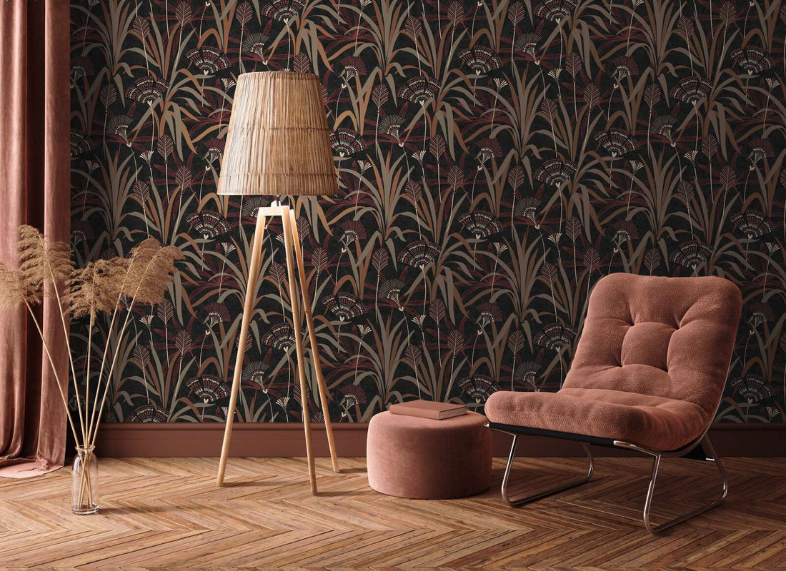 AS Creation French Affair 399364 living room with botanical wallpaper in Beige, Black, Copper, Cream, and Red, shown with a lounge chair and a tripod floor lamp.