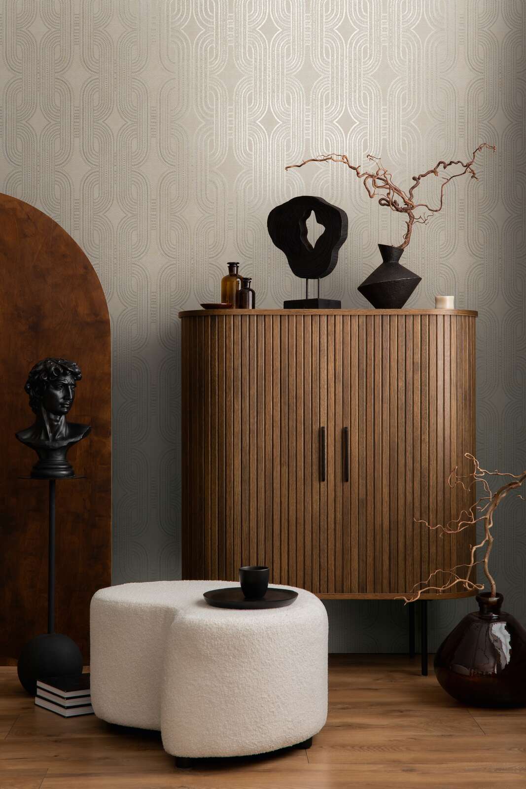 AS Creation French Affair 399371 living room with Beige, Gold, Grey, Metallic geometric wallpaper behind a ribbed wood cabinet and a white ottoman.