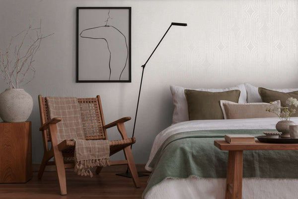 AS Creation French Affair 399372 bedroom with grey and white geometric wallpaper behind a bed and a wooden woven chair.