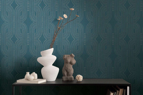 AS Creation French Affair 399373 geometric wallpaper with interlocking arcs made of small dashed lines, shown behind a dark console with sculptural vases and a torso sculpture.