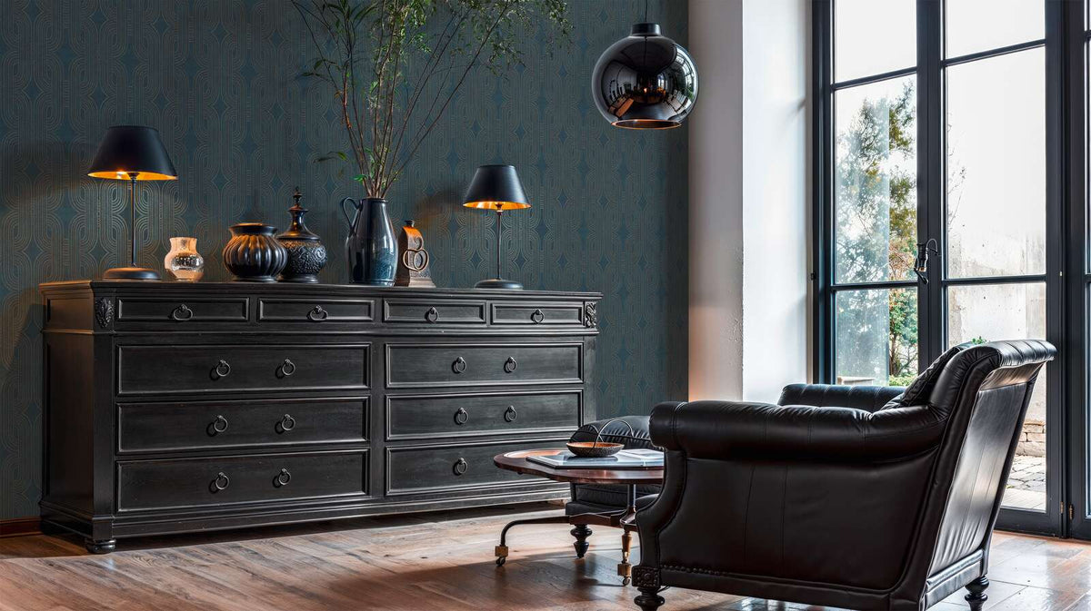 AS Creation French Affair 399373 living room with geometric Art Deco wallpaper in Beige, Blue, Gold, Green, Turquoise, shown with a dark dresser and a leather armchair.