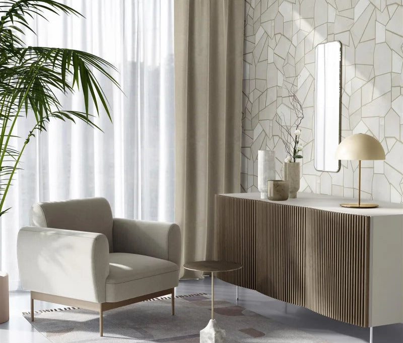 Erismann Elle Decoration 4 beige geometric wallpaper with metallic gold lines and textured finish displayed on a wall in a modern apartment with an elegant sideboard and sofa chair