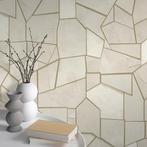 Erismann Elle Decoration 4 beige geometric wallpaper with metallic gold lines and textured finish behind a round table with vases and books