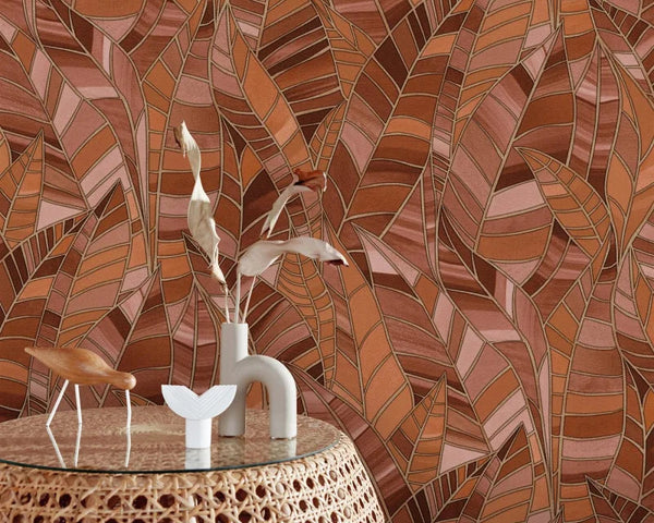 Erismann Elle Decoration 4 terracotta botanical wallpaper with layered leaf pattern and textured finish behind a rattan side table