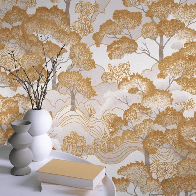 Erismann Elle Decoration 4 scenic tree wallpaper in warm golden tones styled behind an accent table and vase