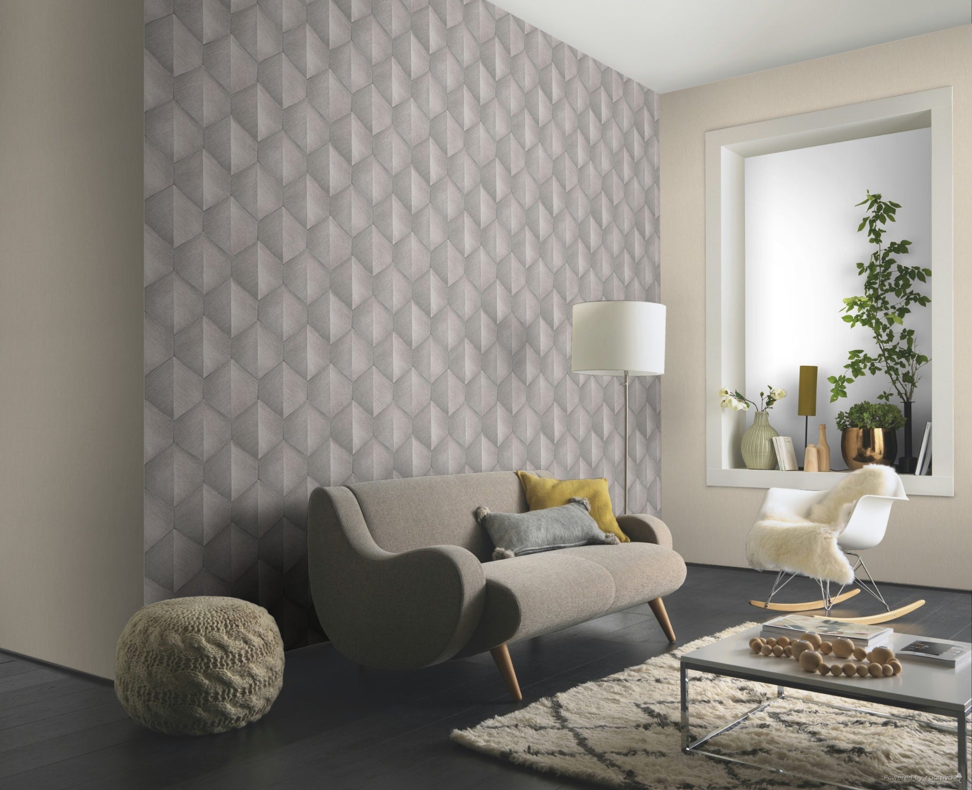 Erismann Fashion For Walls 4 10370-38 wallpaper lounge feature wall with geometric pattern behind curved sofa, floor lamp and rocking chair, low coffee table on a rug, plants in window alcove for a calm contemporary feel.