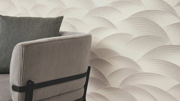 Erismann Fashion For Walls 4 10372-38 wallpaper lounge feature wall with curved layered pattern behind a ribbed upholstered armchair and cushion, calm modern mood.