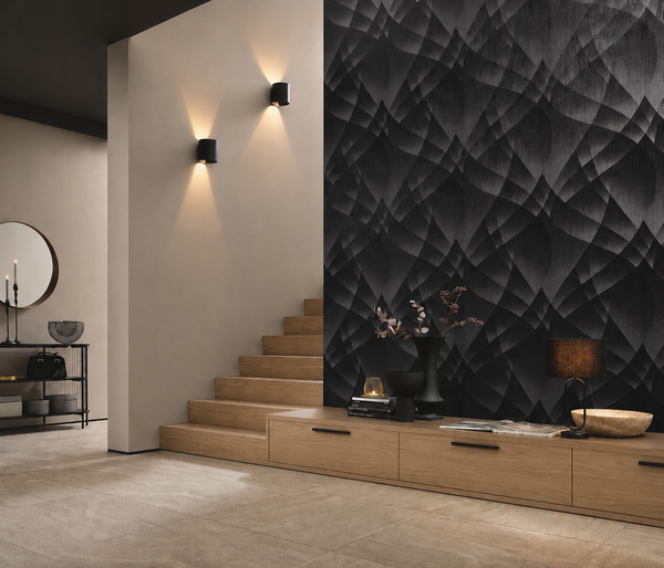 Erismann Fashion For Walls 4 10374-15 wallpaper in a modern lounge feature wall behind a low wood console by the stairs, styled with a lamp, sculptural vases, books and warm wall sconces for a calm, moody feel.