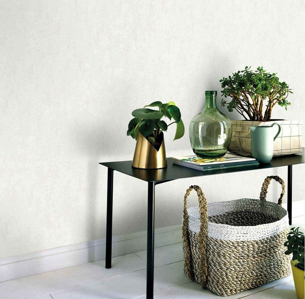 Erismann Fashion For Walls 4 10375-26 wallpaper lounge feature wall with slim black console table, potted greenery, green glass vase and woven basket, calm minimalist vibe.