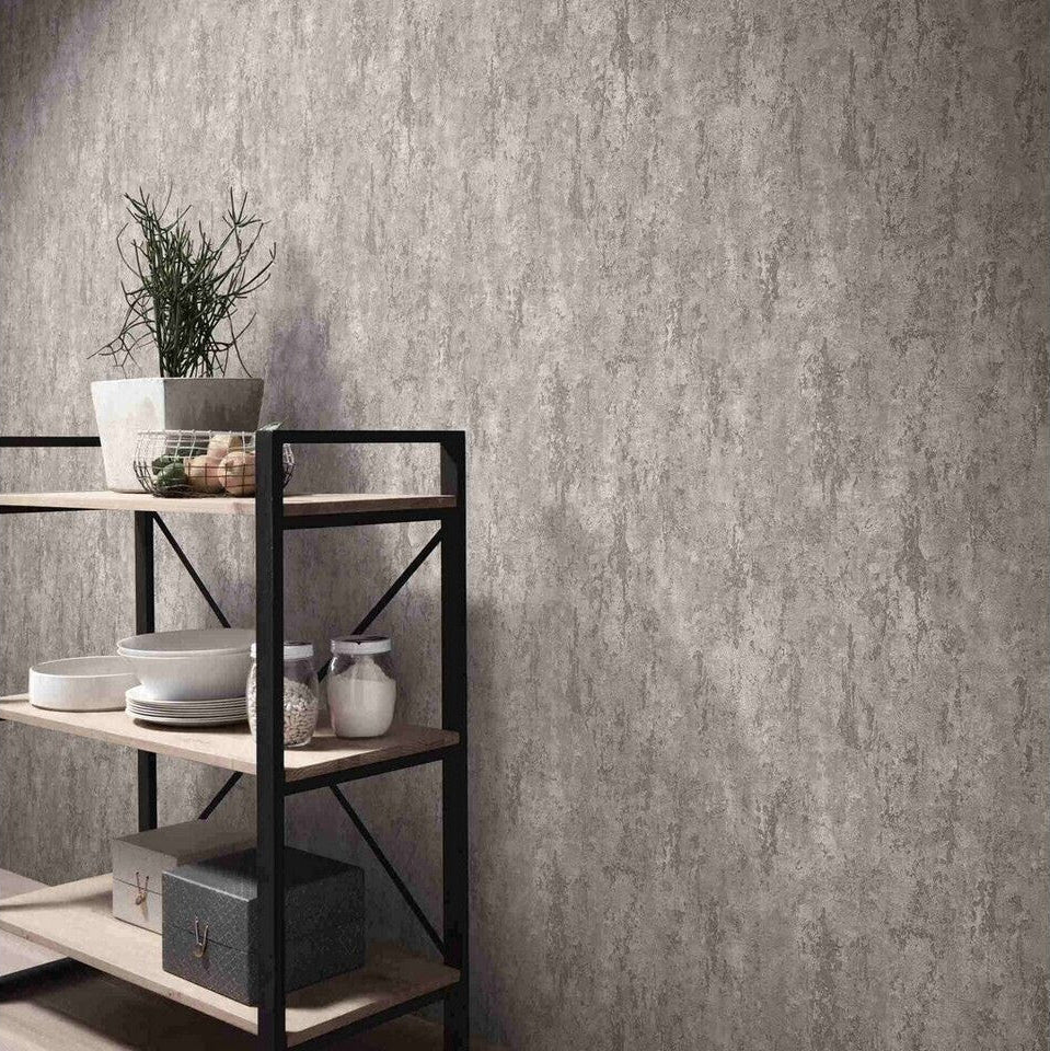 Erismann Fashion For Walls 4 10375-38 wallpaper lounge feature wall with textured concrete-look surface beside black metal and wood shelving holding a potted plant, crockery and storage boxes, creating a calm minimalist vibe.